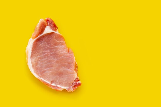 Frisches Schweinefleisch auf gelbem Hintergrund.