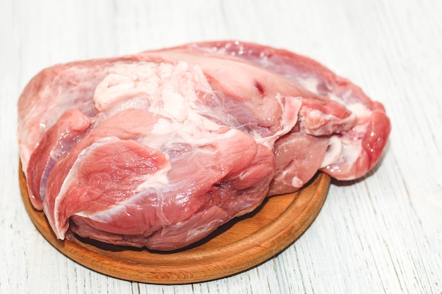 Frisches Stück Fleisch großer Schweineschinken auf dem Brett