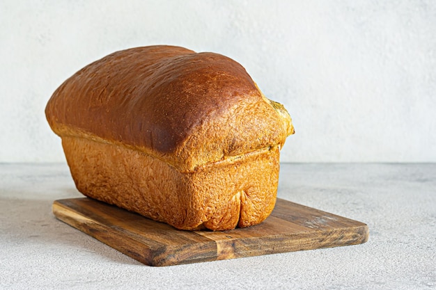 Frisches Toastbrot mit Pesto-Basilikum-Petersilie-Knoblauch-Erdnüssen auf einem Holzbrett