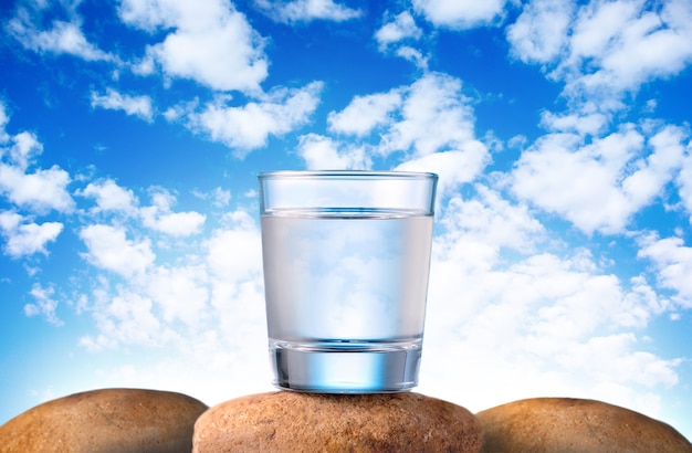 Frisches und sauberes Trinkwasser in Glas auf Steinen