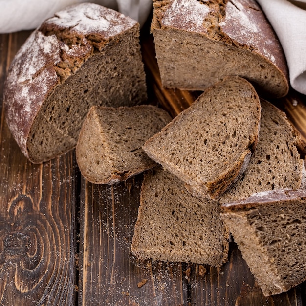 Frisches warmes Brot in Stücke geschnitten und auf altem Holzbrett