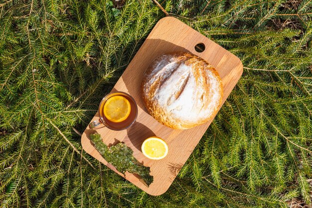 Frisches Weißbrot auf einem Schneidebrett und roter Tee mit Zitrone