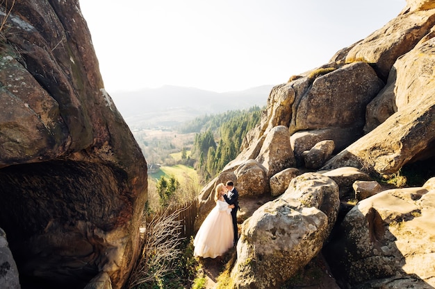 Frischvermählte küssen sich auf einer Klippe mit Blick auf die Berge Concept-Familie hat gerade geheiratet