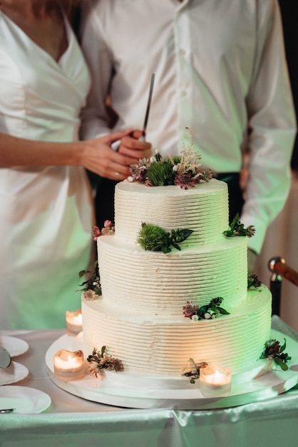 Frischvermählte schneiden, lachen und probieren glücklich die Hochzeitstorte