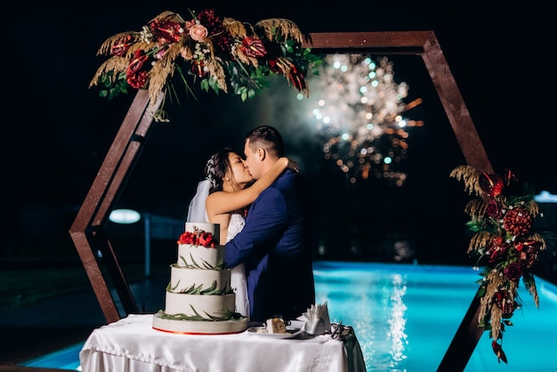 Frischvermählte schneiden, lachen und probieren glücklich die Hochzeitstorte