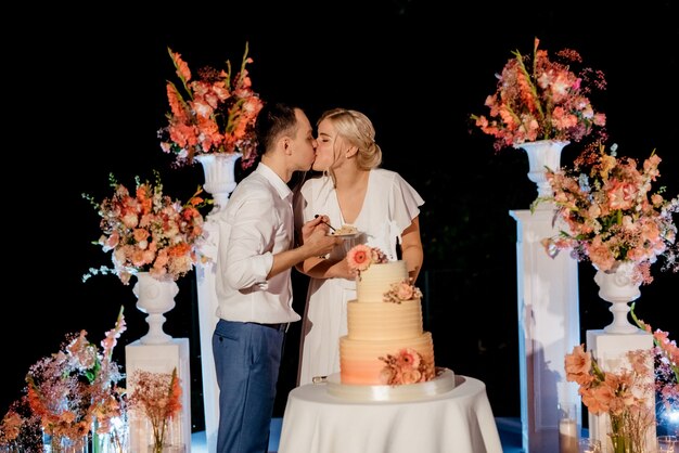 Frischvermählte schneiden, lachen und probieren glücklich die Hochzeitstorte