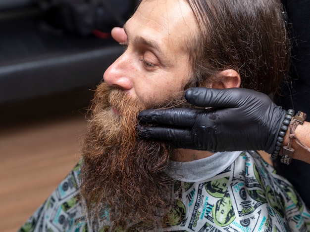 Friseur Auftragen von Creme auf den Bart des Kunden.