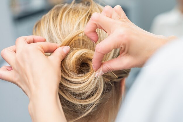 Friseur, der Brauthochzeitsfrisur macht