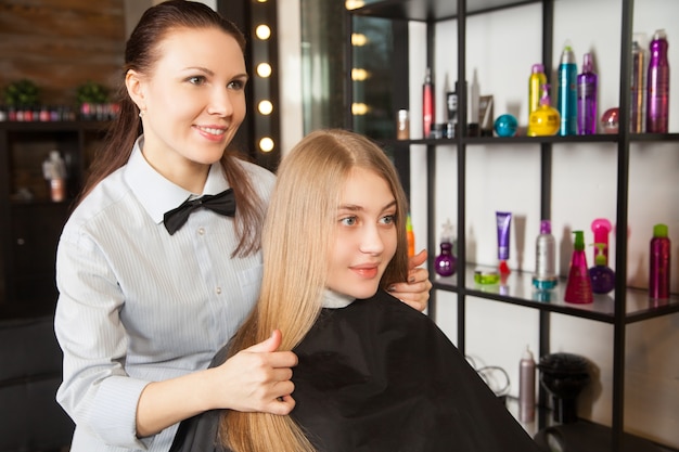 Friseur, der das Haar der Frau berührt Horizontale Innenaufnahme