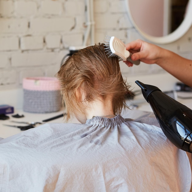 Friseur, der dem süßen kleinen Mädchen eine Frisur macht