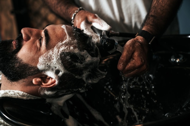 Friseur, der einen Kunden in einem Friseursalon bedient