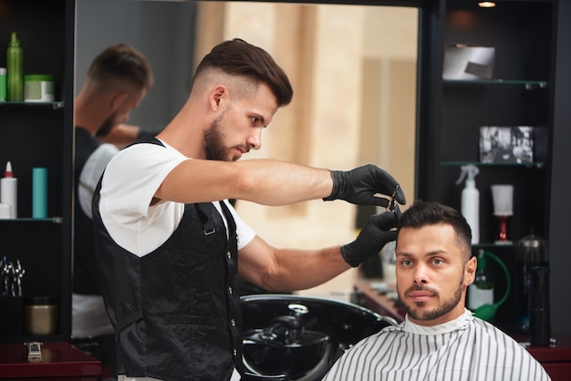 Friseur, der Haarschnitt des Mannes verwendet Kamm und Scheren anredet.