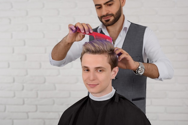 Friseur, der Haarveilchen farbiges Tonen für Jungen tut.