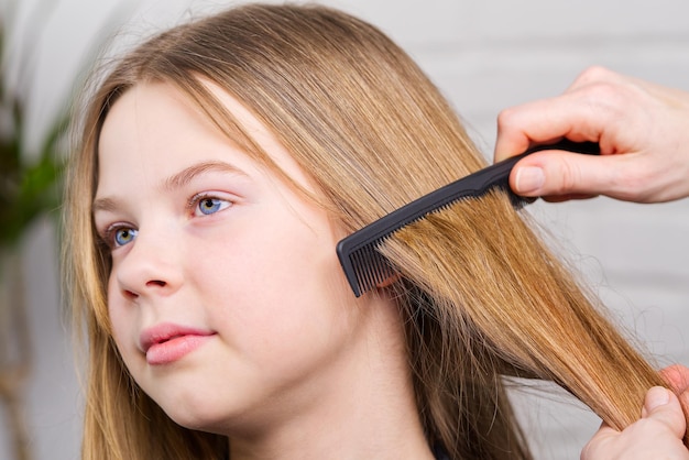 Friseur, der nettes Mädchen im Friseursalon ein Haar macht Junges Mädchen beim Friseur