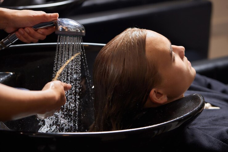 Foto friseur friseur wäscht kundenhaare junger mann entspannt sich im friseur-schönheitssalon