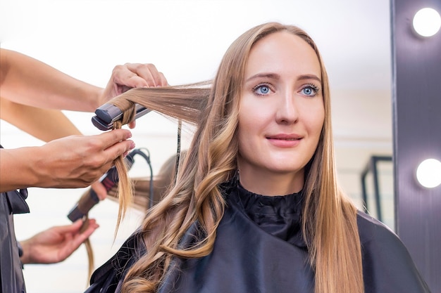 Friseur macht Locken mit einem Lockenstab