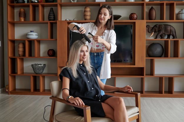 Friseur mit einem Haarglätter im Salon