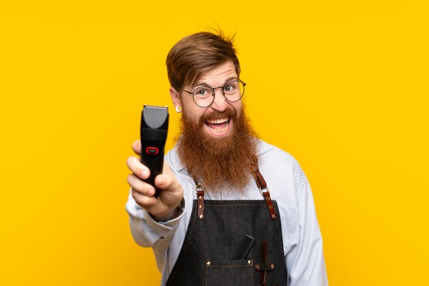 Friseur mit langem Bart in einem Schutzblech über getrenntem gelbem Hintergrund