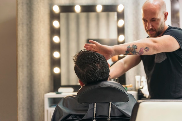 Friseur rasiert einen Mann im Salon