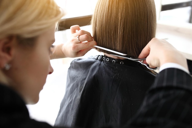 Friseur schneidet braunes Haar mit einer Schere