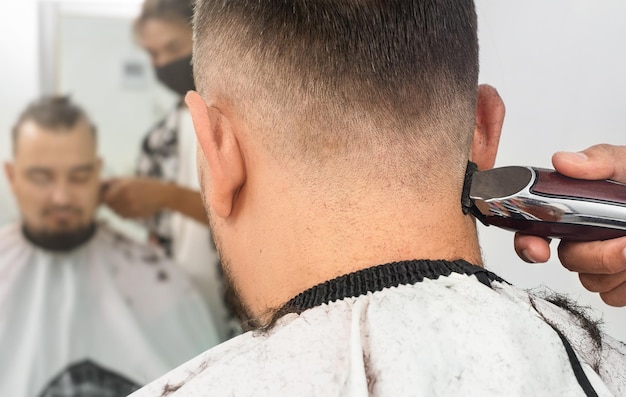 Friseur schneidet einem Mann die Haare