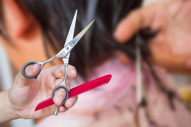 Friseur schneidet Haare mit einer Schere im Schönheitssalon