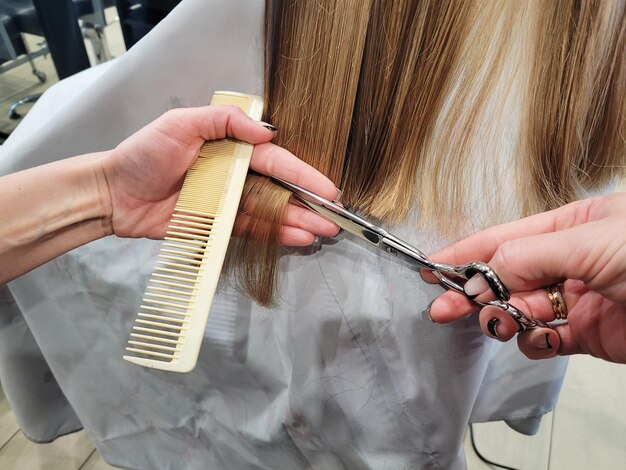 Foto friseur schneidet haare mit schere, verkürzt die haarlänge