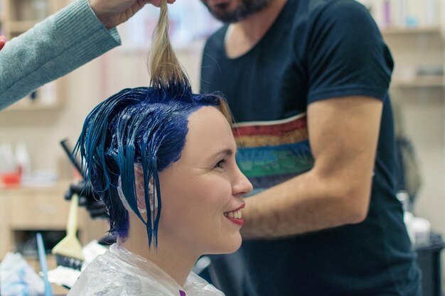 Friseur Stylist färbt die Haare einer Frau im Friseursalon