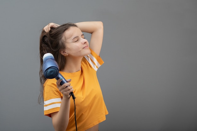 Friseur und schönes Styling. Junge kaukasische Frau trocknet Haare mit einem Haartrockner