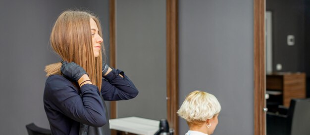 Friseur zieht schwarze Schürze an