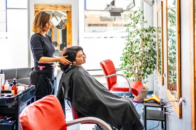 Friseurin betreut einen Kunden im Salon