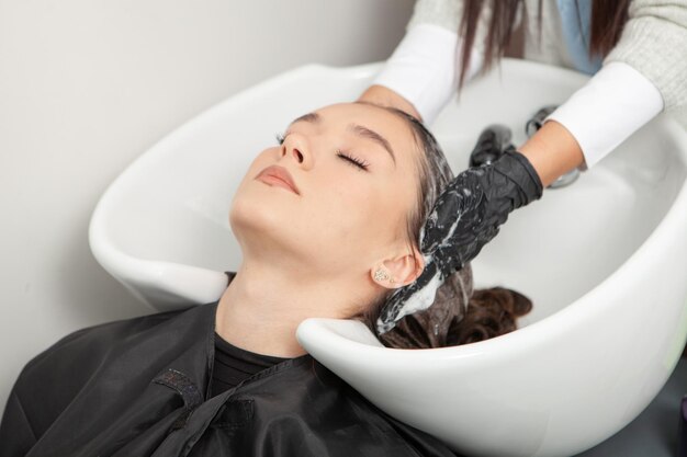 Foto friseurin wäscht die haare einer frau in einem schönheitssalon