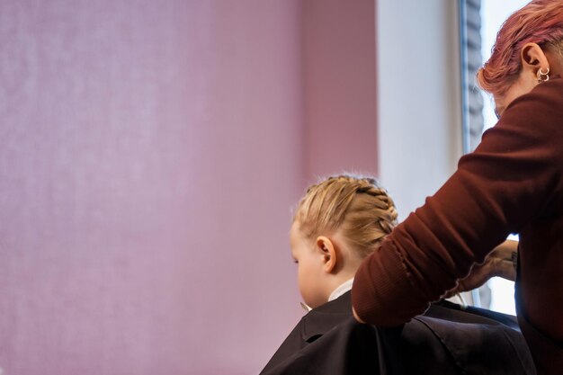 Friseursalon Konzept Frisur Schönheit Friseur macht Frisur für stilvolles Baby im Friseursalon