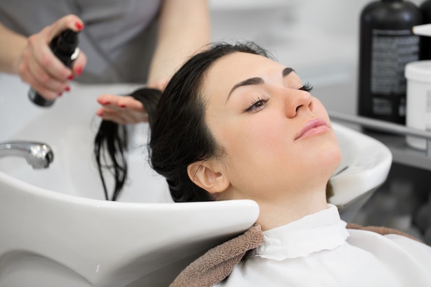 Friseurspritzer auf dem Haarspray des Kunden zum einfachen Kämmen