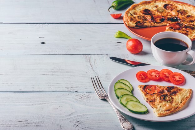 Fritada com chouriço, tomate e pimenta no prato e café.