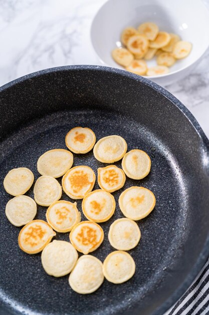 Fritando o cereal de mini panqueca em uma frigideira antiaderente.