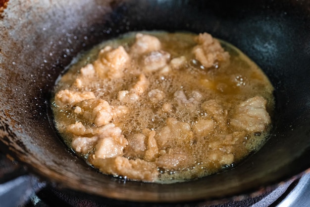 Fritar carne de frango frito crocante com óleo fervente em frigideira no fogão a gás