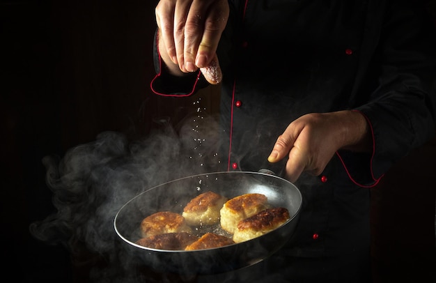 Foto fritar deliciosos oladyi para o pequeno-almoço o cozinheiro salga as panquecas em uma frigideira espaço preto para o menu ou receita