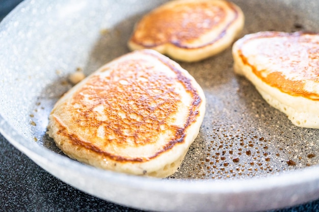 Fritar panquecas à base de kefir na panela em um fogão elétrico.