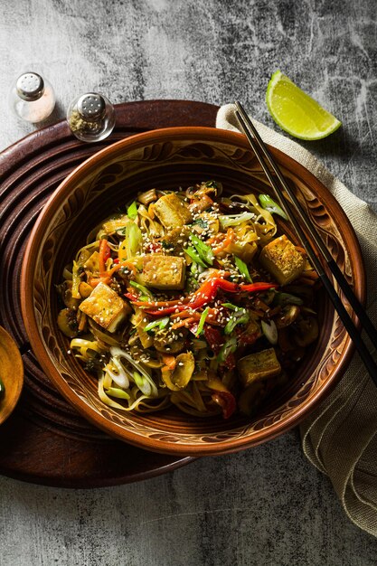 Frite vegano asiático com macarrão de arroz de tofu e legumes vista superior