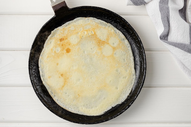 Frito de panquecas finas ou crepes em uma frigideira O processo de fazer panquecas passo a passo