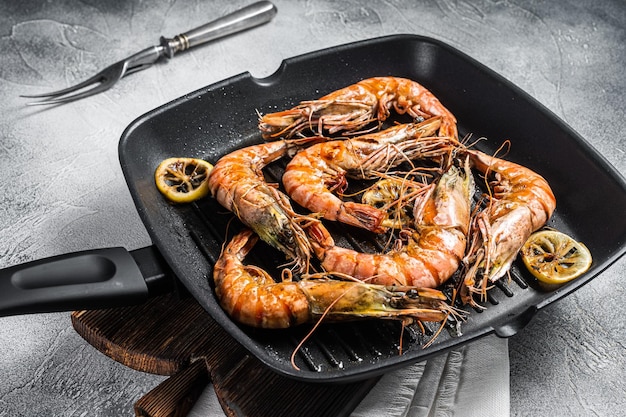 Frito en sartén a la parrilla Gambas tigre negro gigante Camarones con limón y hierbas Fondo gris Vista superior