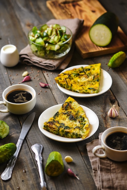 Frittata con guisantes, espinacas y calabacín Almuerzo en la campiña italiana