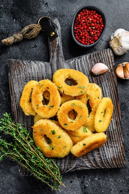 Frittierte Tintenfisch-Calamari-Ringe auf einem Schneidebrett paniert