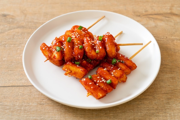 frittierter koreanischer Reiskuchen (Tteokbokki) mit scharfer Sauce aufgespießt - koreanische Küche