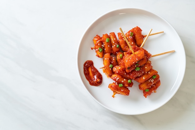 frittierter koreanischer Reiskuchen (Tteokbokki) mit scharfer Sauce aufgespießt - koreanische Küche