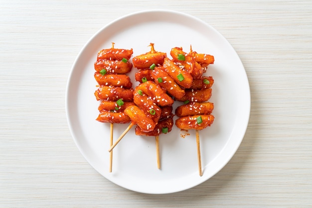 frittierter koreanischer Reiskuchen (Tteokbokki) mit scharfer Sauce aufgespießt - koreanische Küche