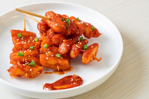 frittierter koreanischer Reiskuchen (Tteokbokki) mit scharfer Sauce aufgespießt - koreanische Küche