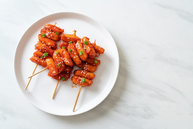 frittierter koreanischer Reiskuchen (Tteokbokki) mit scharfer Sauce aufgespießt - koreanische Küche