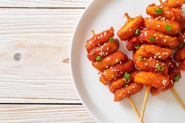 frittierter koreanischer Reiskuchen (Tteokbokki) mit scharfer Sauce aufgespießt - koreanische Küche